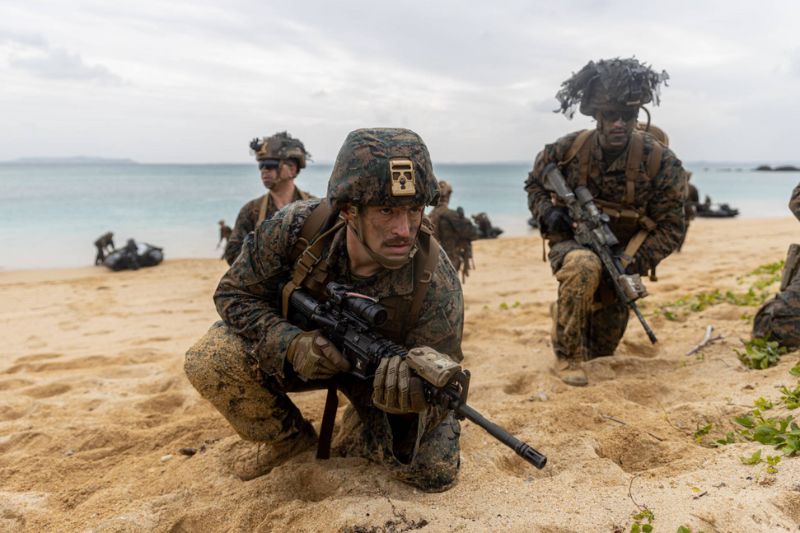Fuzileiros Navais dos EUA com a 31ª Unidade Expedicionária Marinha fornecem segurança durante um exercício de invasão por barco no Camp Schwab, na Prefeitura de Okinawa, em 14 de dezembro. | CORPO DE FUZILEIROS NAVAIS DOS EUA.