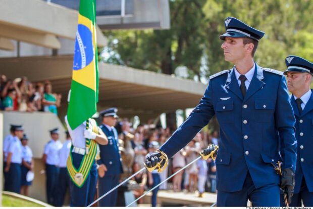 Oficiais recém-formados da Força Aérea Brasileira prestam continência à bandeira nacional.