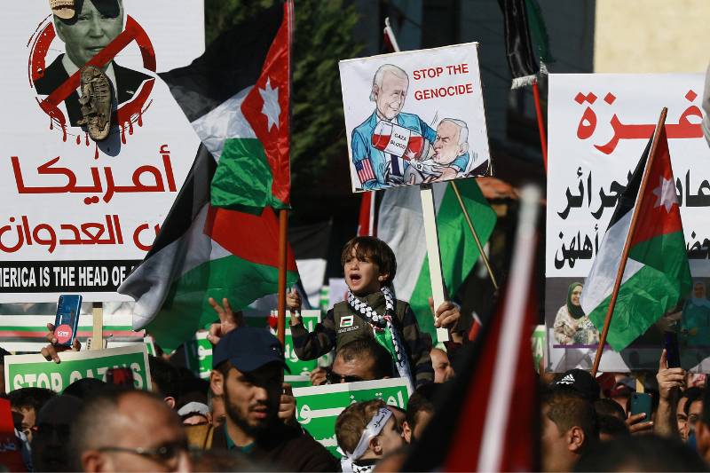 As pessoas entoam slogans e agitam bandeiras palestinas e jordanianas durante uma manifestação perto da embaixada dos EUA na capital, Amã, em solidariedade ao povo de Gaza, em 15 de dezembro de 2023, em meio às contínuas batalhas entre Israel e o grupo militante Hamas. (Foto de Khalil MAZRAAWI/AFP)