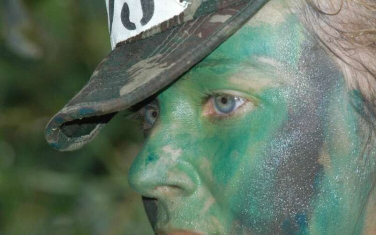 Mulher militar do Exército Brasileiro durante treinamento inicial. Ela está usando camuflagem