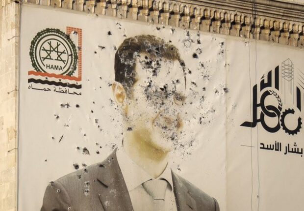 Mural com foto de Bashar al-Assad amanhece crivado de balas após a queda da Síria.