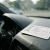 Dirigir com a CNH vencida há mais de 30 dias custa R$ 293,47, sete pontos na carteira e o carro retido até aparecer outro motorista habilitado; o código dá 30 dias de tolerância e depois disso a infração é gravíssima